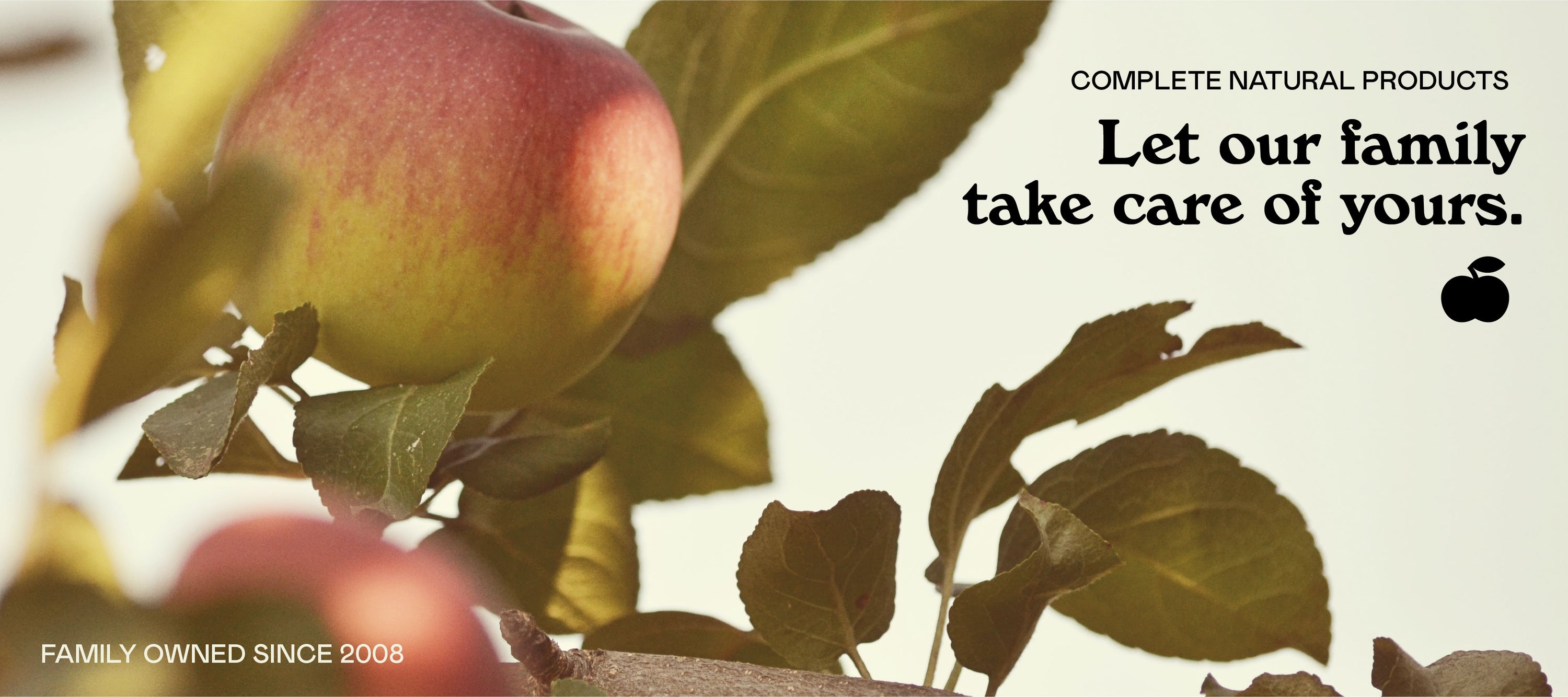 Close-up of apples and leaves on a tree branch. Text reads: Complete natural products. Let our family take care of yours. Family owned since 2008. Apple icon shown. Background is light with a natural, organic feel.